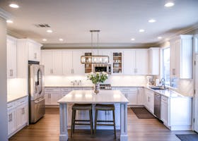 Spacious and elegant kitchen featuring white cabinetry, island, and stainless steel appliances.